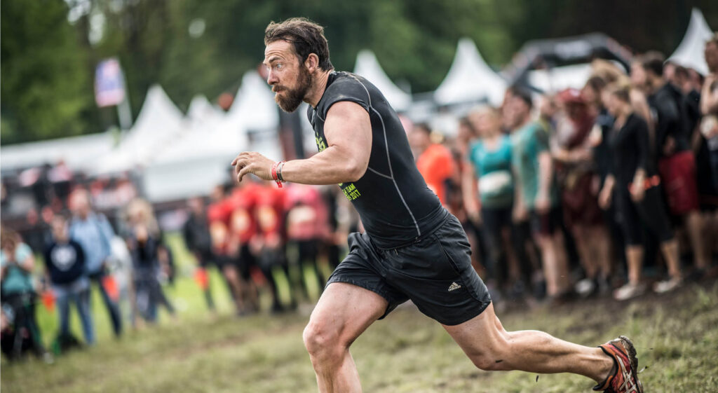 Mann rennt vor Zuschauern auf etwas zu